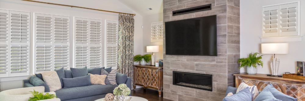 Plantation shutters in a Logan family room with fireplace