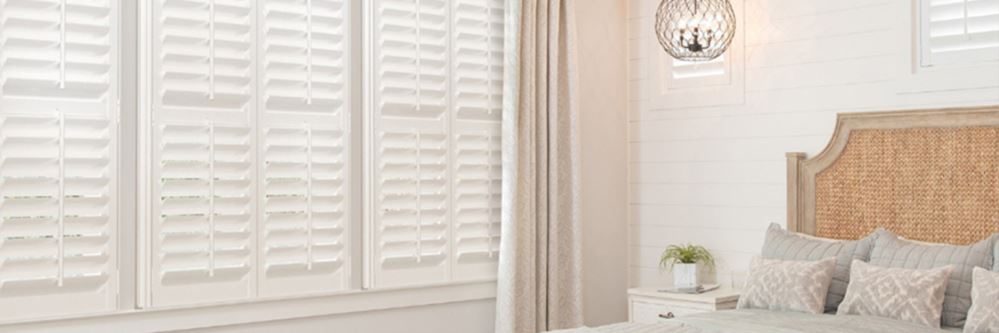 White Polywood shutters in a white bedroom.